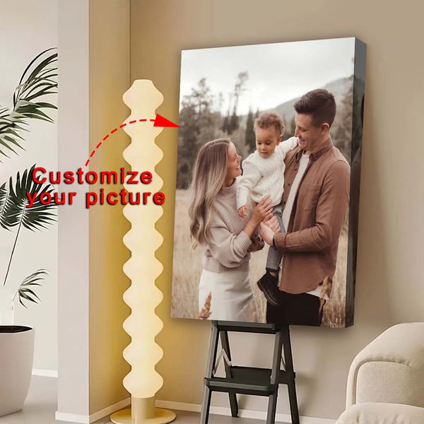 A custom printed canvas wall art photo of a father and son is displayed next to a tall, glowing light sculpture.