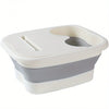 A white and gray collapsible foot soak bucket with massage dots.