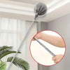 A close-up view of an adjustable length metal cleaning broom hanging on a ceiling, with a hand holding the handle.