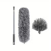 A long aluminum pole with a brush head, next to a fluffy gray cobweb duster.