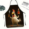 A black apron shaped like a rooster, featuring a cartoon illustration of a proud rooster holding a fork and a bottle.