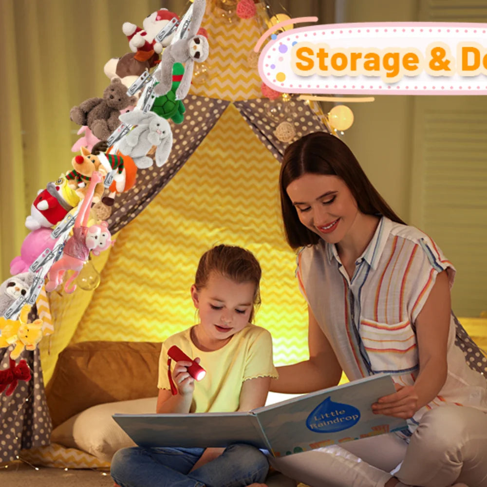 A woman is sitting with a child in front of a yellow tent decorated with stuffed animals and a Bohemian cotton hanging storag