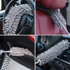 Close-up view of an extendable microfiber duster with a bendable handle being used on a car interior surface.