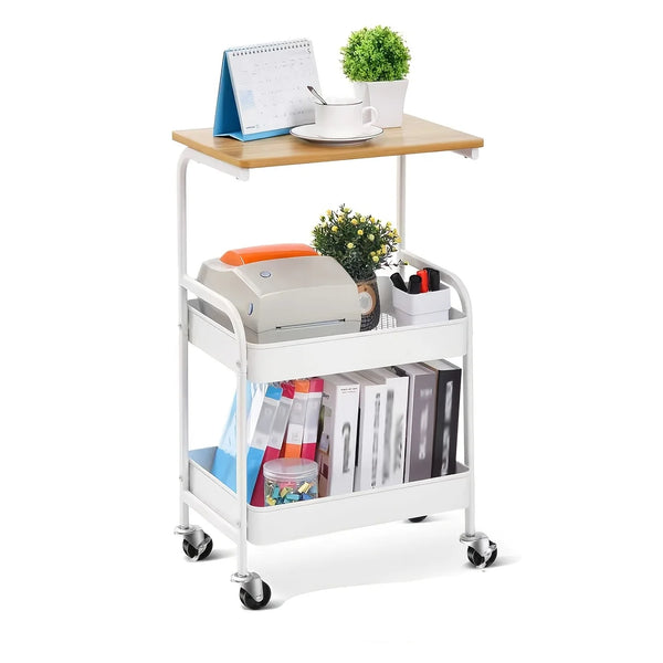 A white 3-tier rolling storage cart with a wooden top holding stationery and a small potted plant.
