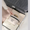 A beige foldable travel duffel bag is shown inside a gray suitcase, demonstrating its design.