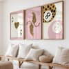 Drei gerahmte Leinwandkunstwerke mit Leoparden- und Gepardenmustern in Gold auf rosa Hintergrund.