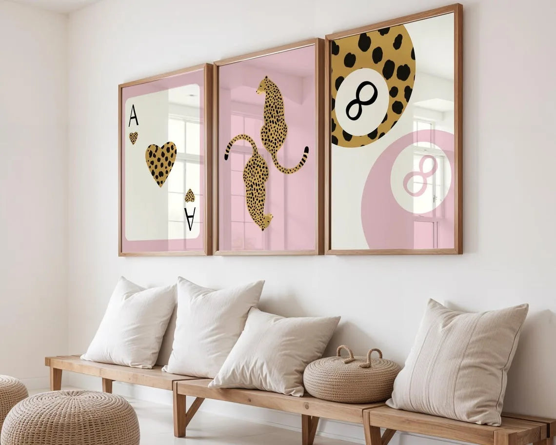 Drei gerahmte Leinwandkunstwerke mit Leoparden- und Gepardenmustern in Gold auf rosa Hintergrund.