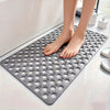 Alfombrilla de ducha de PVC gris antideslizante con orificios de drenaje sobre una superficie blanca.