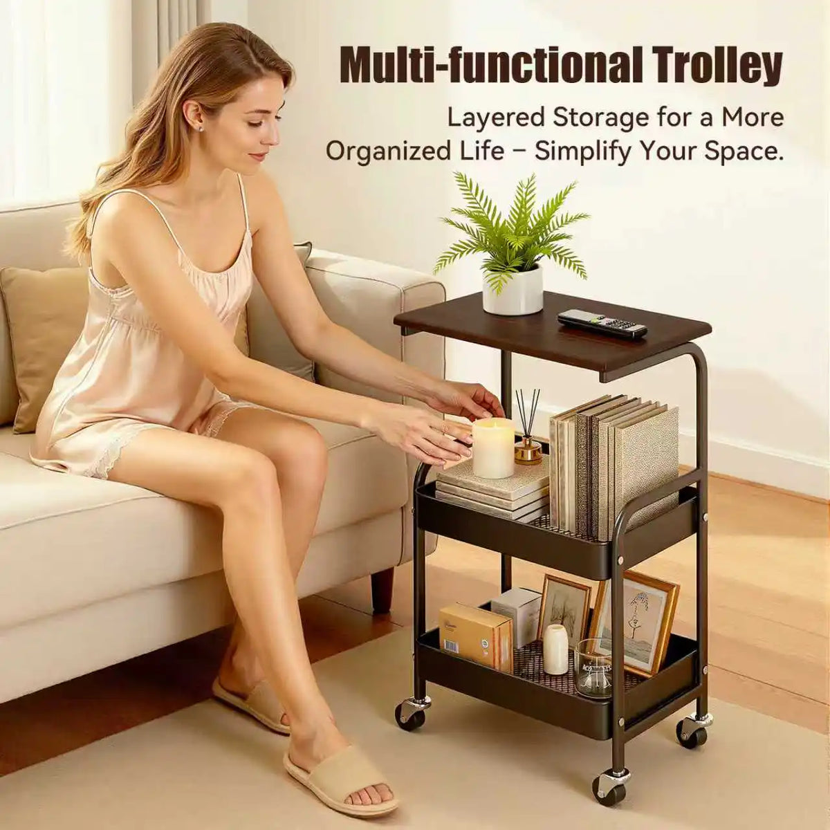 A multi-functional trolley with a wooden top and three tiers of storage is shown next to a woman on a sofa.
