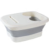 A white and gray collapsible foot soak bucket with a contoured insert for massage dots.