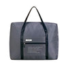 A dark gray foldable travel duffel bag with black straps and a luggage sleeve.