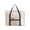 A beige foldable travel duffel bag with black straps and a leather-look luggage sleeve.