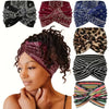 A woman wearing a patterned elastic knot yoga and fitness headband with dark curly hair.