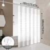 White striped shower curtain hanging on a rod in a bathroom setting