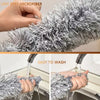 Close-up of a silver lint-free microfiber duster being washed under running water.