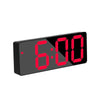 A black digital alarm clock displaying 6:00 with red LED numerals.