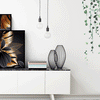 Black and gold leaf canvas art displayed on a white shelf with green foliage wall decor.