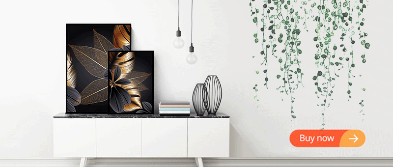 Black and gold leaf canvas art displayed on a white shelf with green foliage wall decor.