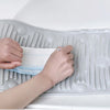Manos colocando un paño blanco sobre una tabla de lavado de silicona transparente para limpiar.
