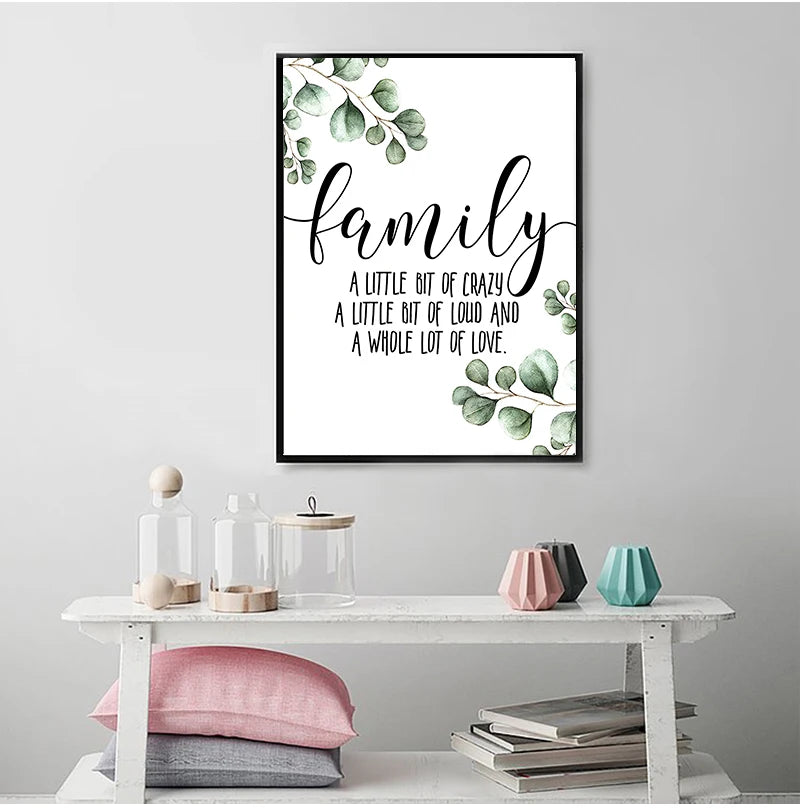 A framed canvas art print featuring the word family in elegant script surrounded by green leaves.