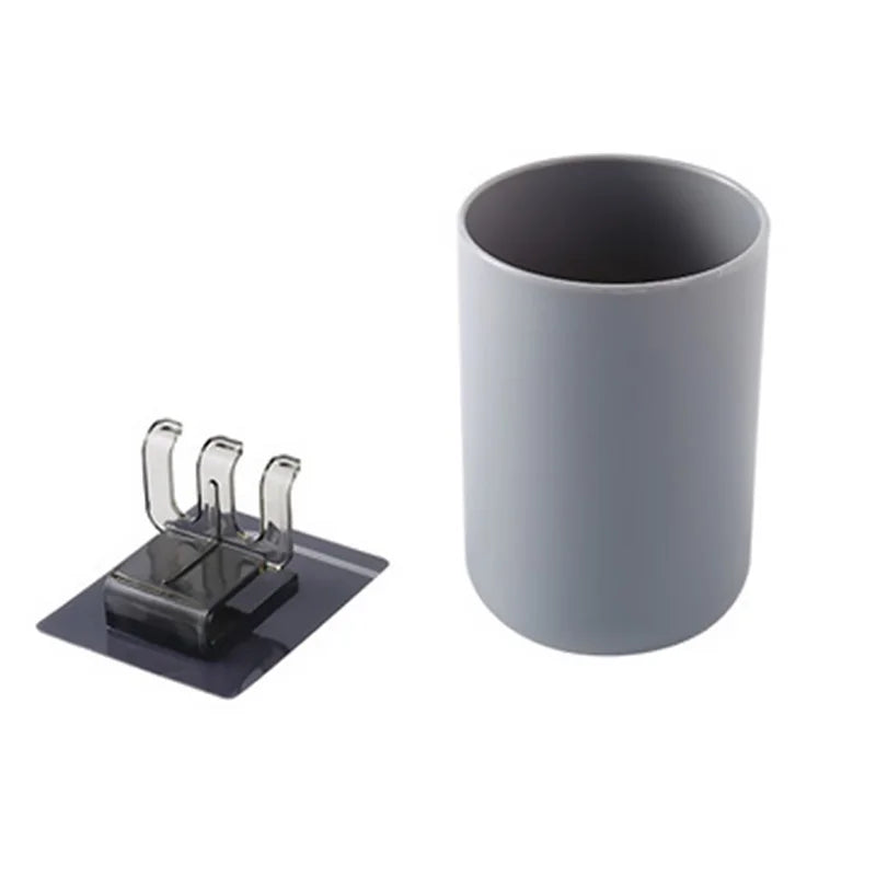 A gray wall mounted organizer featuring a cup and toothbrush holder.