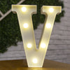 A white alphabet letter V made of LED lights illuminating a brick wall background.