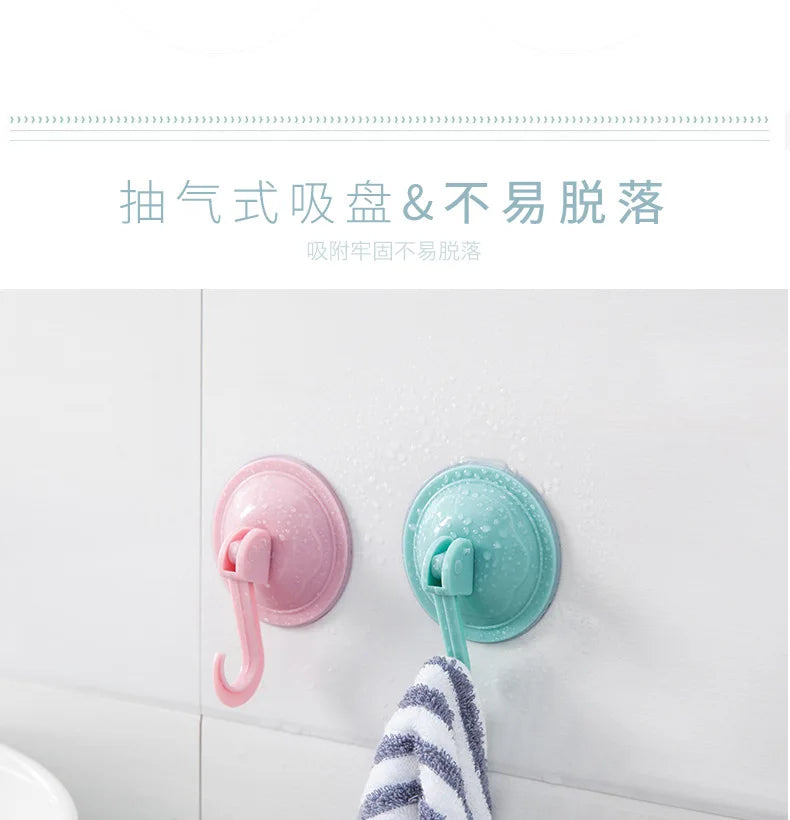 Pink and teal suction cup hooks for waterproof grip on a white wall