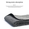 A stack of dark gray microfiber cleaning towels used for drying items.