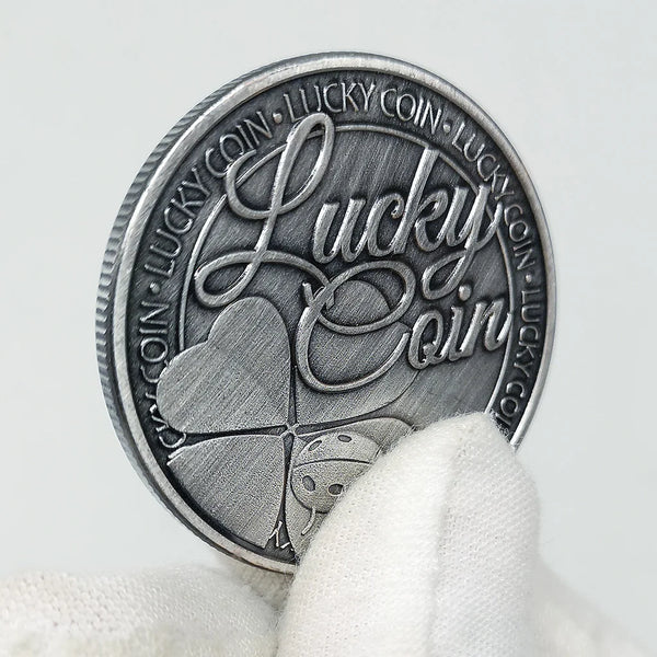 Moneda conmemorativa plateada con un trébol de cuatro hojas y el texto 'Lucky Coin'