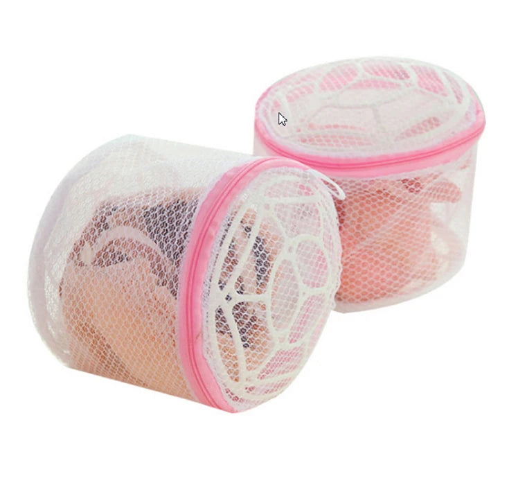 A pink reusable mesh bag used for washing lingerie or delicate items.