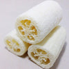 A roll of natural loofah sponge showing the porous texture and light yellow color.