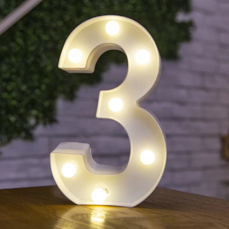 A white LED light sign shaped like the number three, illuminating the surface below.