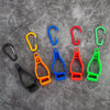 A collection of colorful durable glove clips and buckles arranged on a gray surface.