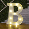 A glowing white letter B made of LED lights sitting on a wooden surface.