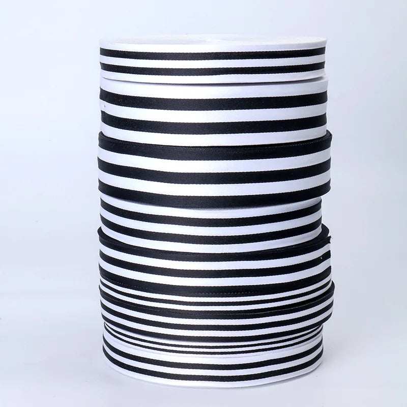 A stack of black and white striped grosgrain ribbon for crafting and decorating.