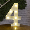 A glowing white LED light shaped like the number four rests on a wooden surface.