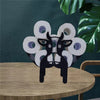 Black novelty animal toilet paper holder made of stacked white cardboard rolls