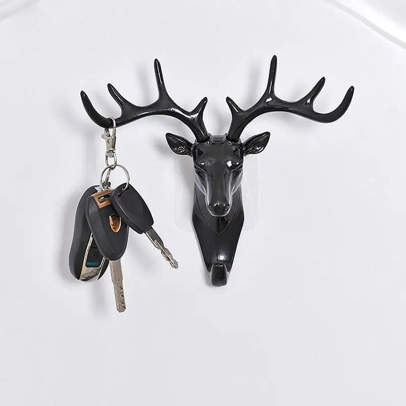 A black deer head wall hook featuring antlers, used for hanging accessories.