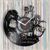 A black vinyl record wall clock featuring a silhouette of a lion king and a crown against a background of records.