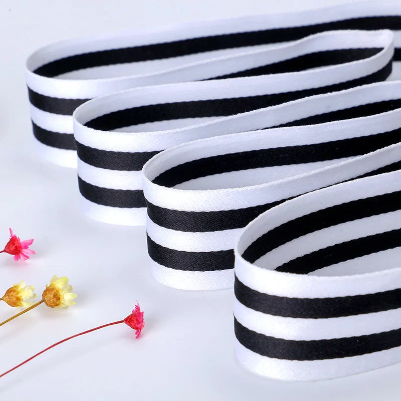Black and white striped double-sided grosgrain ribbon rolled into several strips