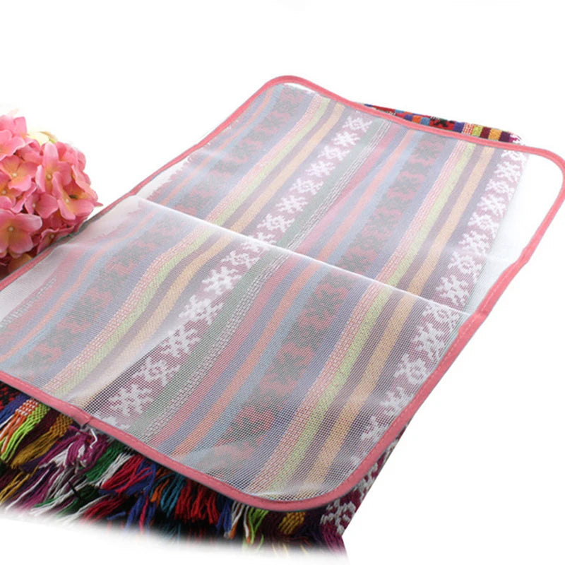 A pink ironing protection mesh pad with striped fabric and fringe is shown.