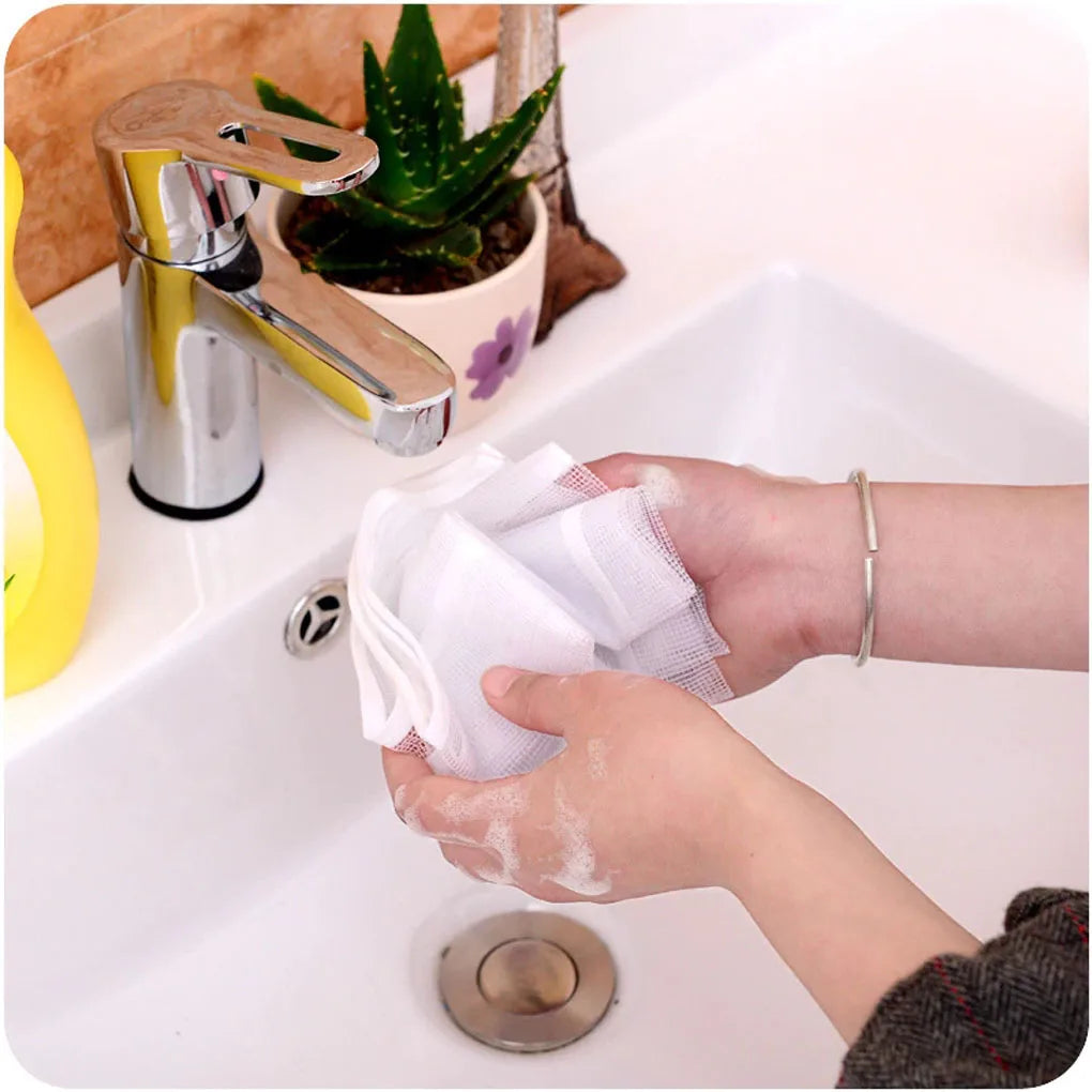 Hands are using a white ironing cloth to wipe down a chrome iron faucet in a white sink.
