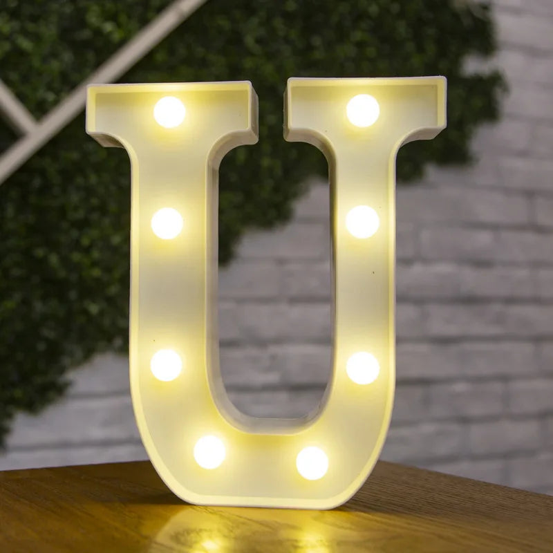 A white alphabet light fixture shaped like the letter U, illuminating the surface below.