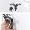 A black vintage deer head wall hook with antlers is displayed against a white background.