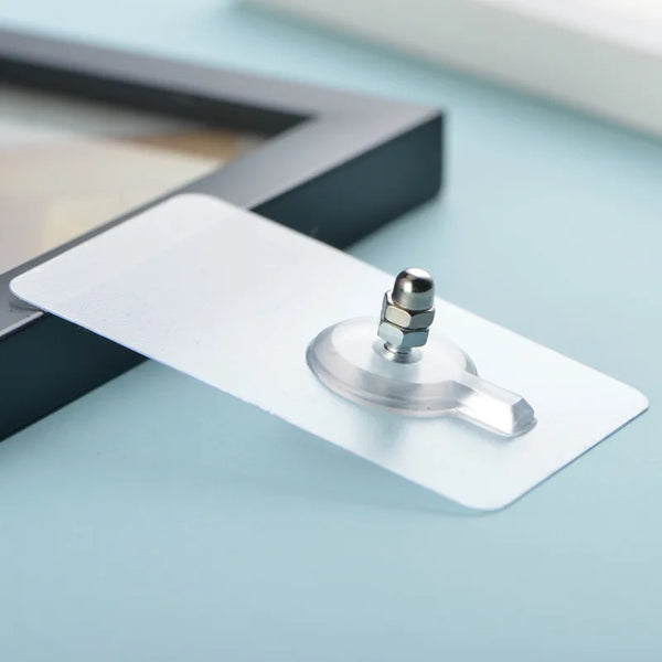A white self-adhesive wall hook with a silver mounting post is shown resting on a light blue surface.