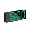 A black digital alarm clock displaying 6:00 with bright green LED numbers.
