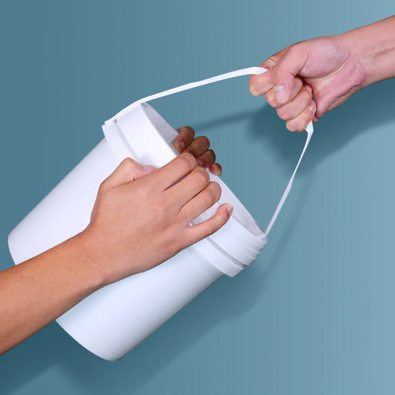 A hand is holding a white leakproof food grade storage bucket with a white strap against a blue background.