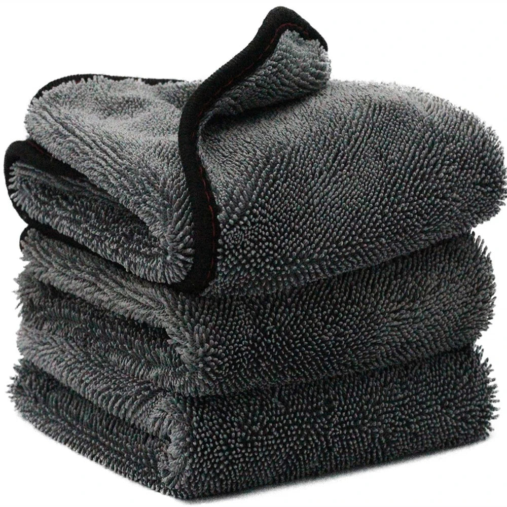 A stack of dark gray microfiber car cleaning and drying towels.