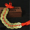 Handmade red knot feng shui coins for prosperity on a string with an orange tassel