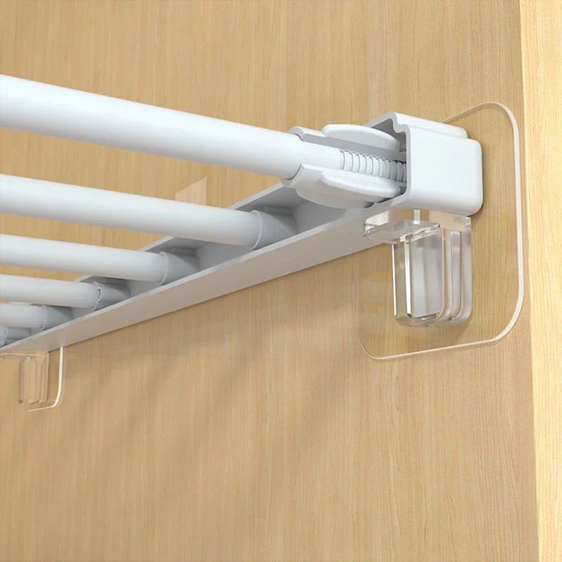 White adhesive shelf support pegs mounted on a wooden cabinet surface.